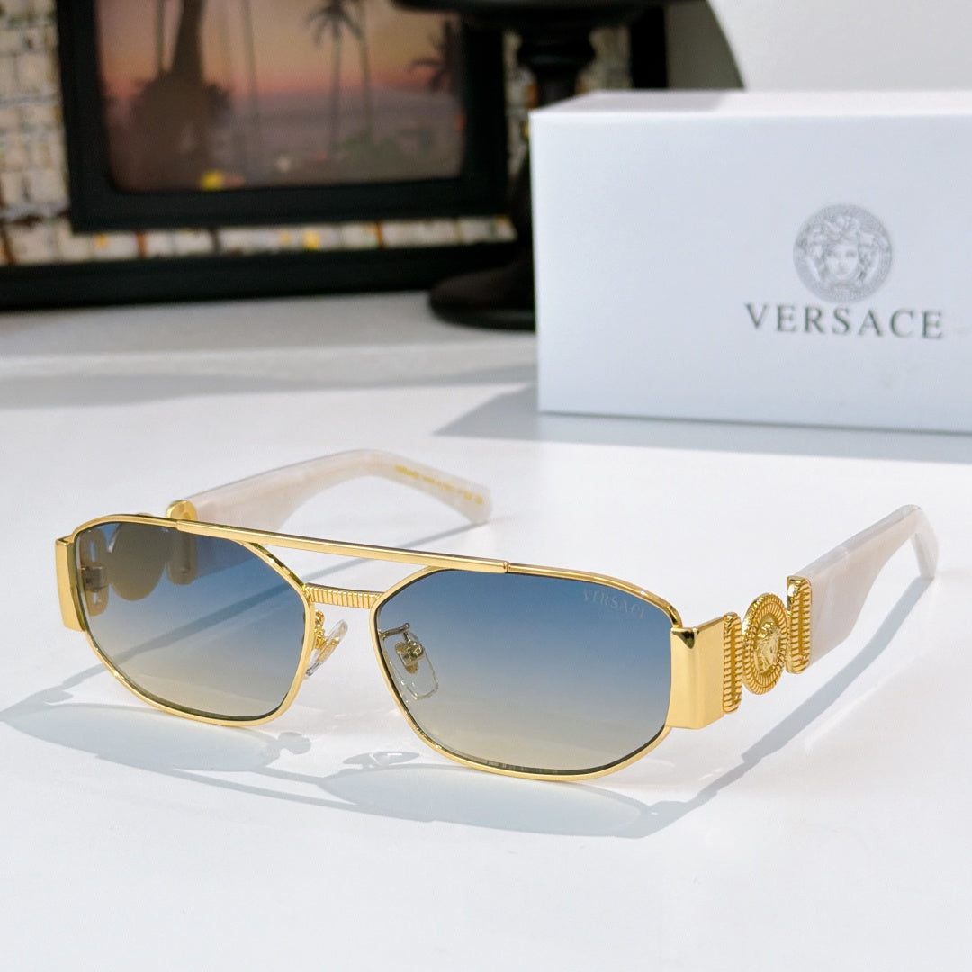 Gold sunglasses with blue lenses and decorative temple logo detail