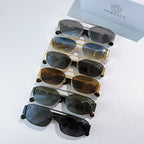 Assorted sunglasses with mixed frames and tinted lenses, stacked on display