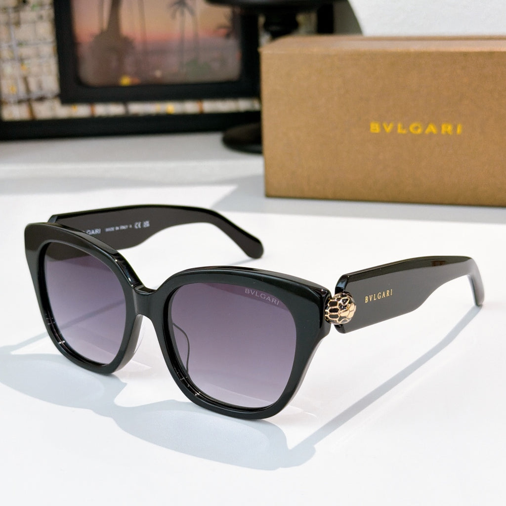 Cat-eye sunglasses with black frames, dark purple lenses, and gold-tone jewel bridge