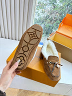 Loafer sole with patterned rubber tread, brown suede upper and shearling lining