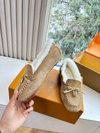 Unisex taupe suede loafer with white shearling lining and metal tassel detail