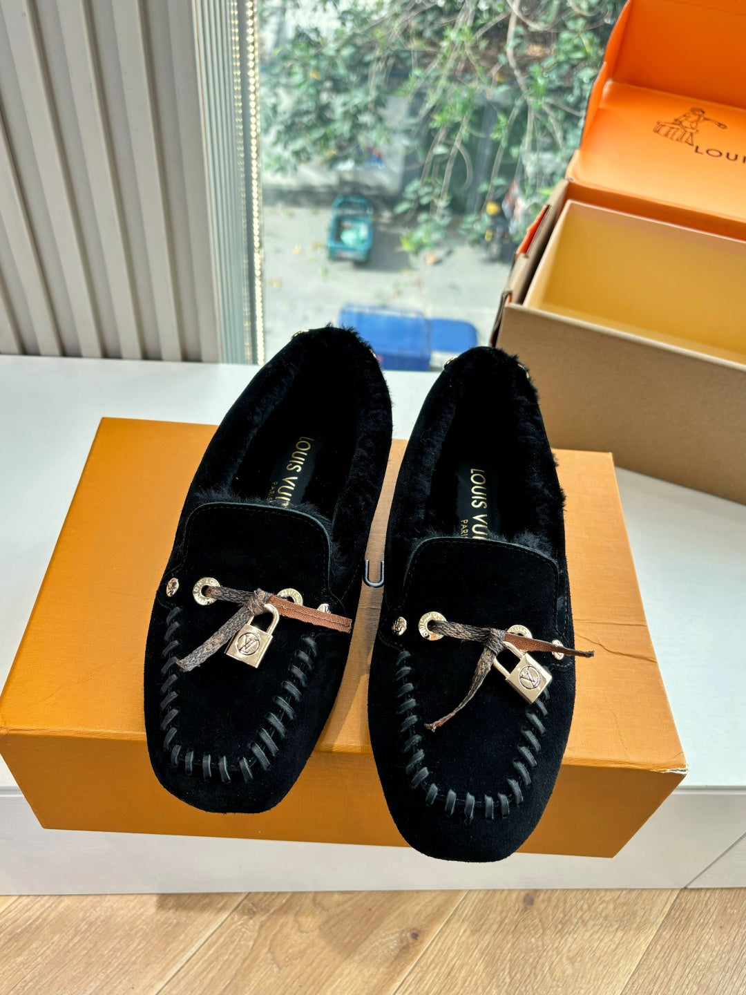 Black suede loafers with silver rope lace bow and metal LV charm