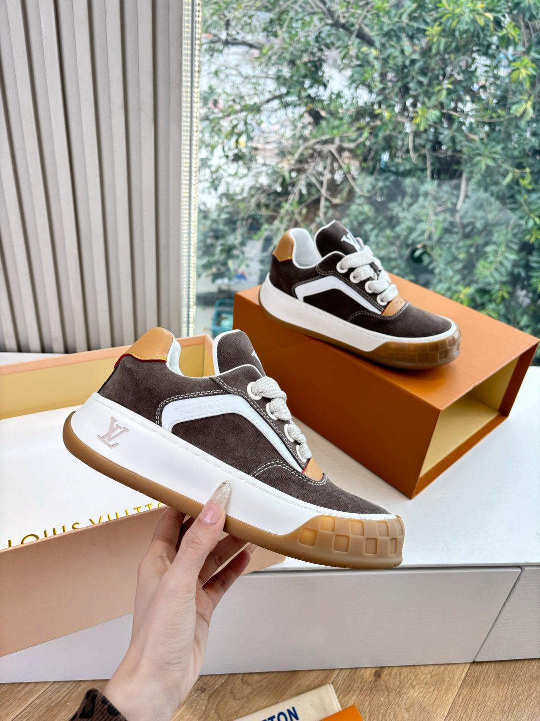 Brown and white low-top sneakers with tan-trimmed panel, lace-up front, gum sole.