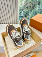 Pair of brown suede low-top sneakers with white stripes, LV-style tongue logo, gum soles.