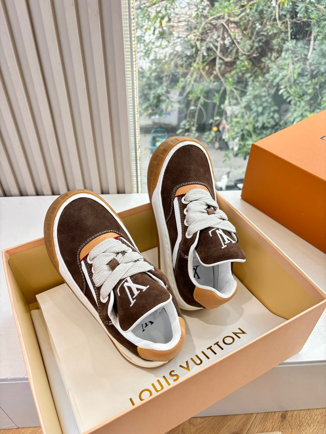 Brown and white low-top sneakers with white laces and LV monogram side detail