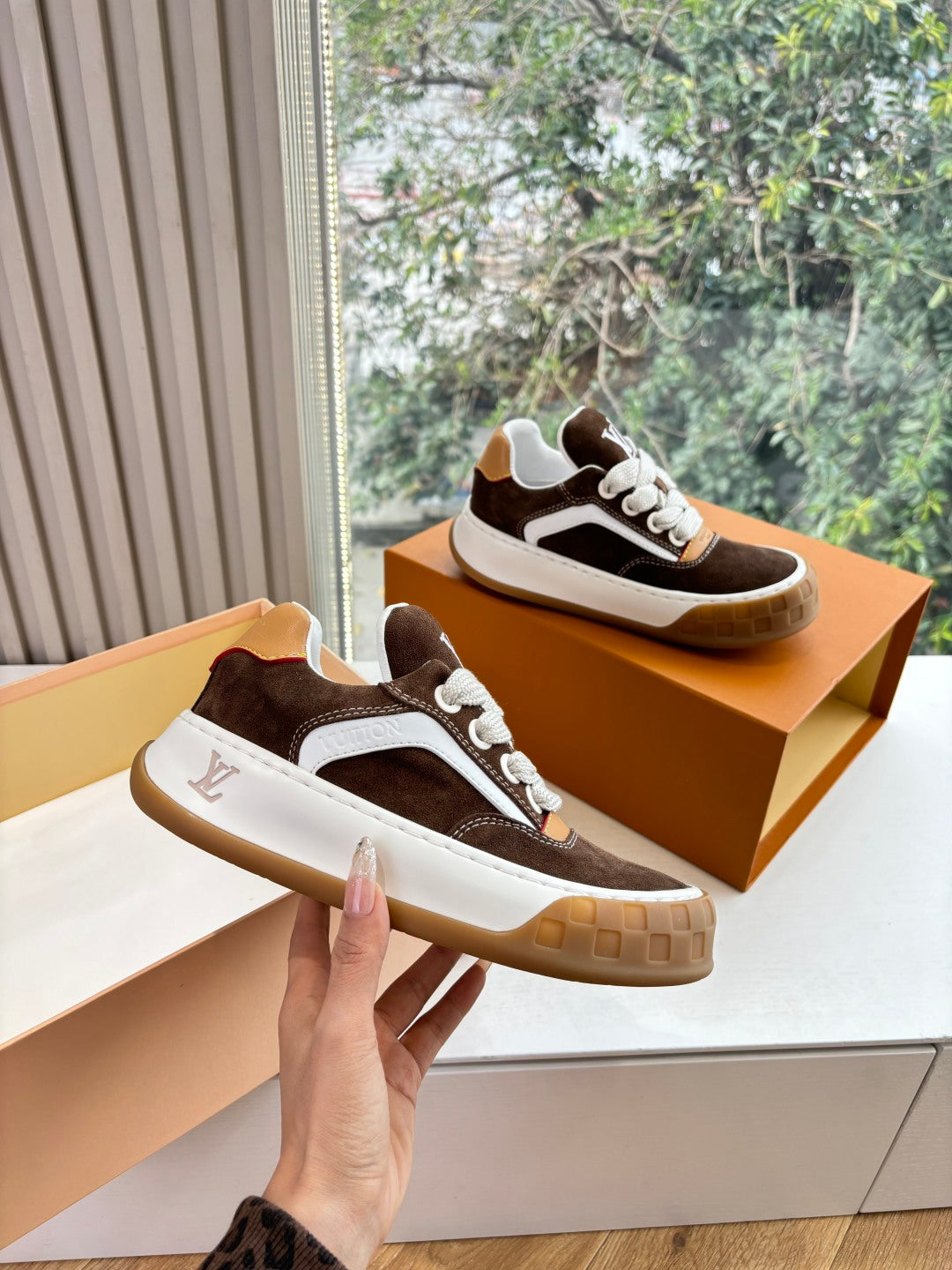 Brown and white low-top sneakers with white laces and gum rubber sole