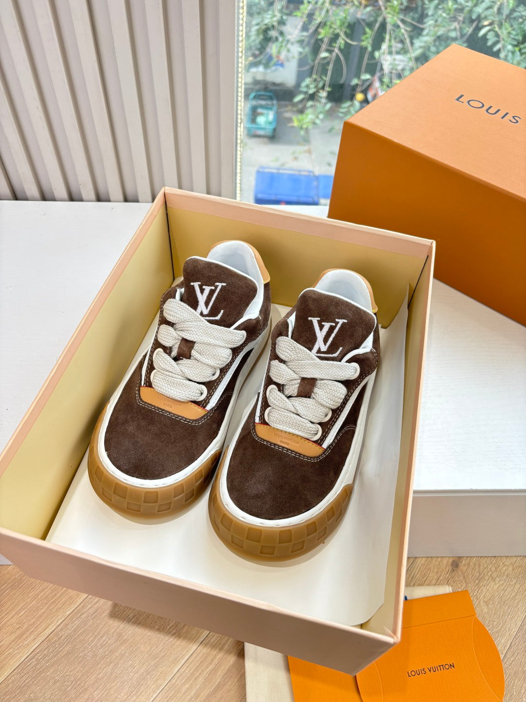 Brown and white low-top lace-up sneakers with white LV monogram on side