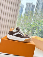 Brown suede low-top sneakers with white side stripes, LV-style logo, gum sole.