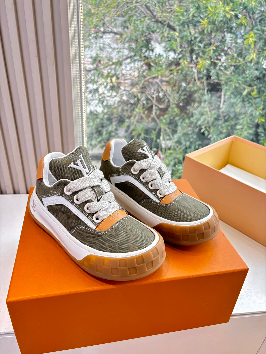 Unisex Louis Vuitton sneakers, dark green uppers, white laces, orange heel tabs, gum soles.