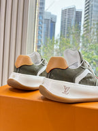 Unisex Louis Vuitton sneakers, dark green uppers with tan heel tabs, white side stripe, laces.