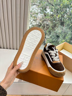 Sneakers outsole view: brown and white rubber tread with LV branding on bottom.