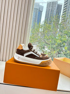 Brown and white low-top lace-up sneakers with white laces and gum sole