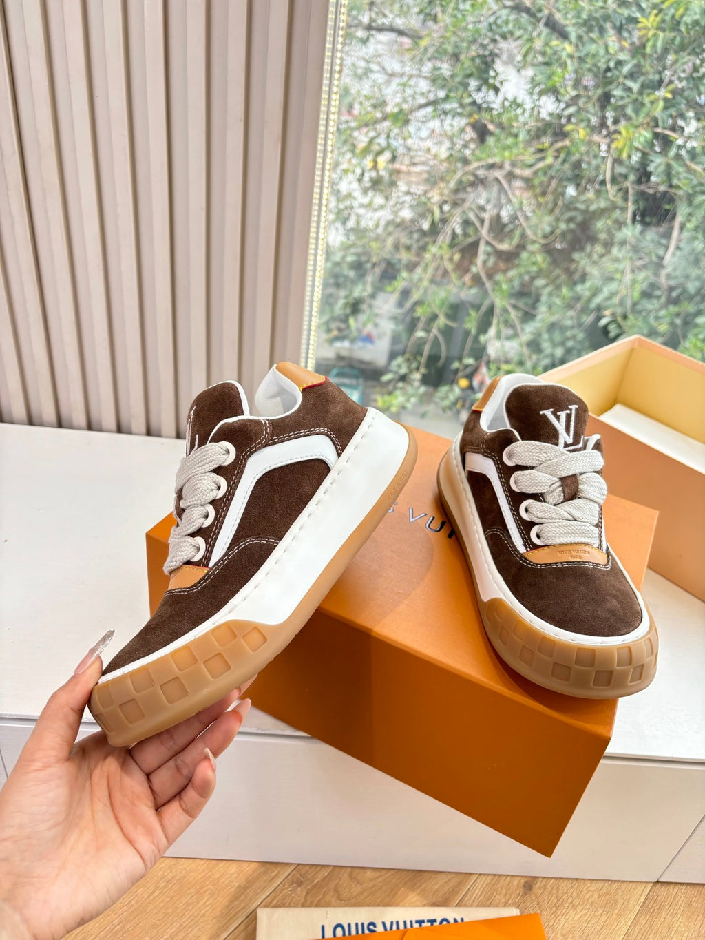 Brown and white low-top sneakers with white panels, laces, and gum sole