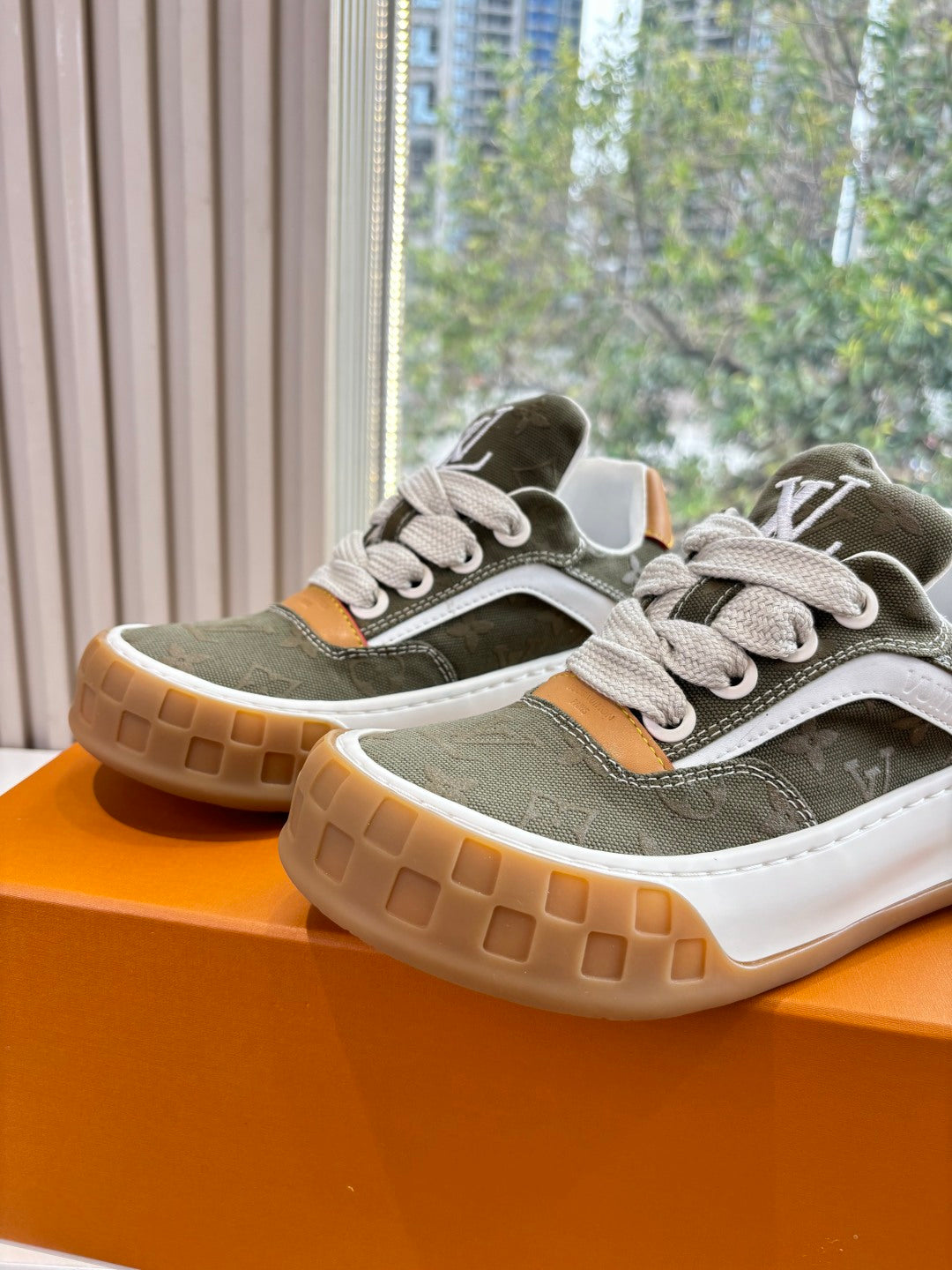 Unisex Louis Vuitton sneakers, dark green upper, white laces, white midsole, gum sole tread.