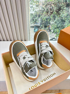 Unisex Louis Vuitton sneakers with dark green uppers, white laces, orange trim, gum sole.