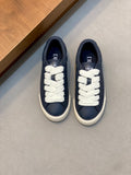 Navy low-top sneakers with white laces and Dior branding on the tongue