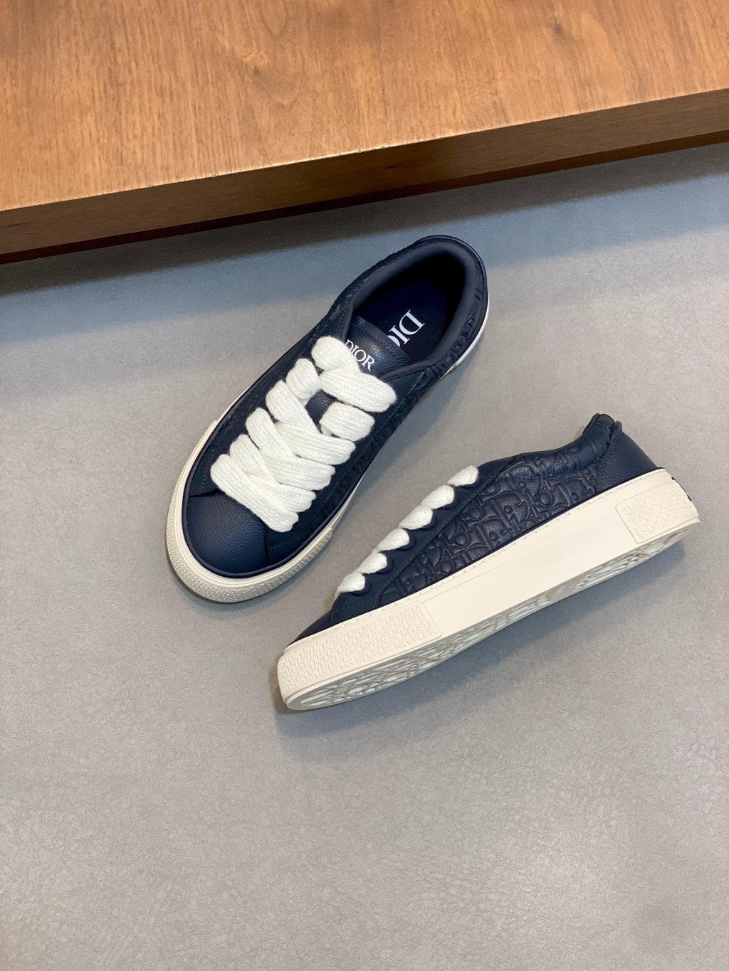 Pair of navy low-top sneakers with white laces and white rubber sole