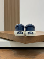 Back view of navy low-top sneakers showing heel pull tabs and Dior logos