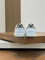 Back view of white sneakers with patterned heel lining and low profile rubber soles