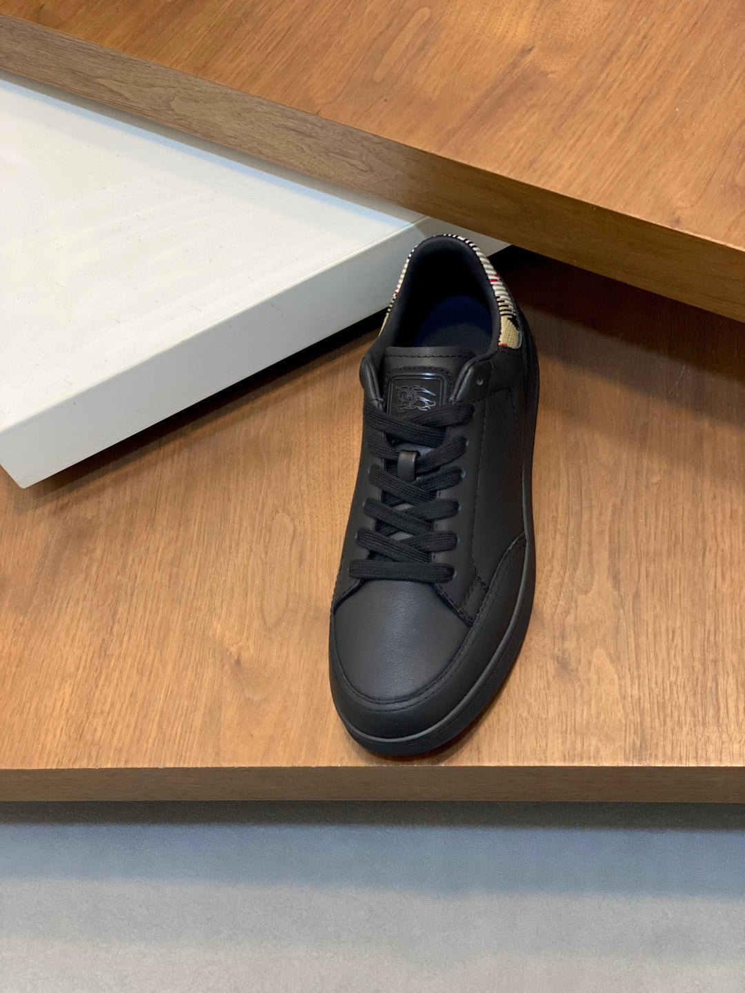 Black low-top lace-up sneakers with textured leather upper