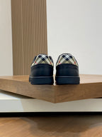 Black low-top sneakers with plaid heel lining and rear tabs