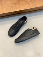 Black low-top sneakers with lace-up vamp and plaid tongue