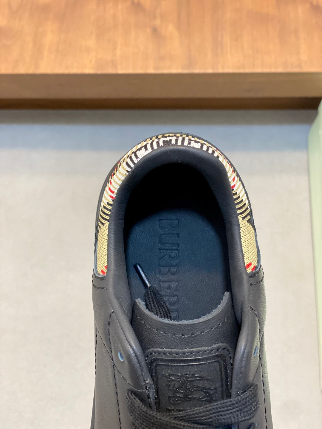 Black sneaker insole with Burberry lettering and plaid trim