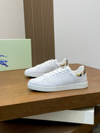 Pair of white low-top sneakers on display, lace-up front and patterned lining