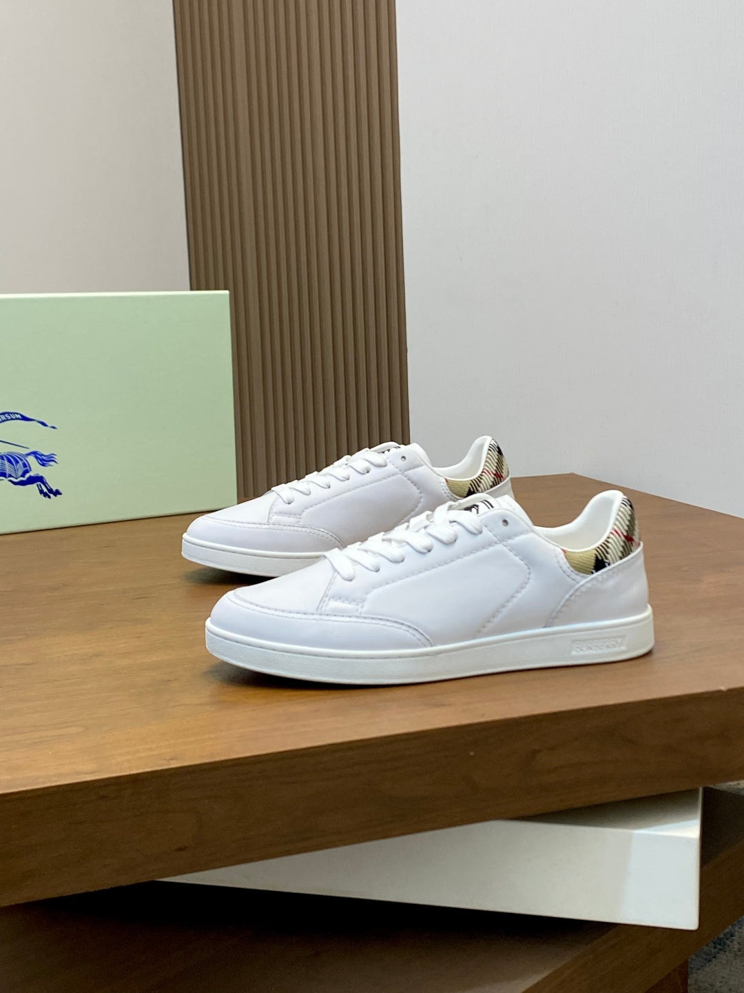 Pair of white low-top sneakers on display, lace-up front and patterned lining