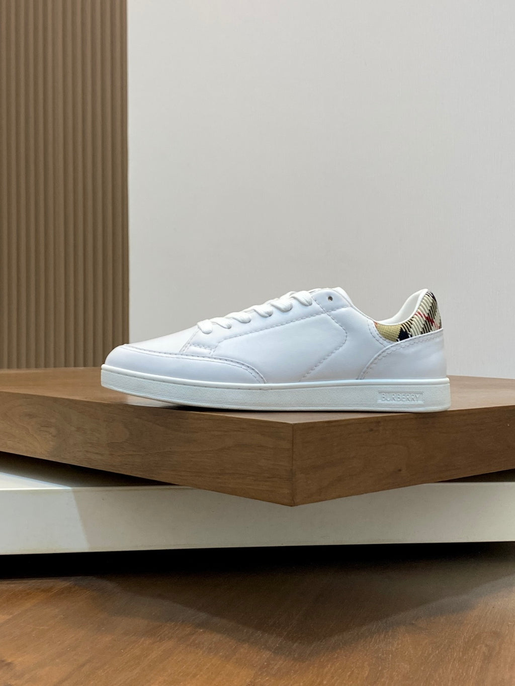 White low-top sneakers with laces and side panel stitching, patterned collar trim