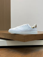 White low-top sneakers with laces and side panel stitching, patterned collar trim