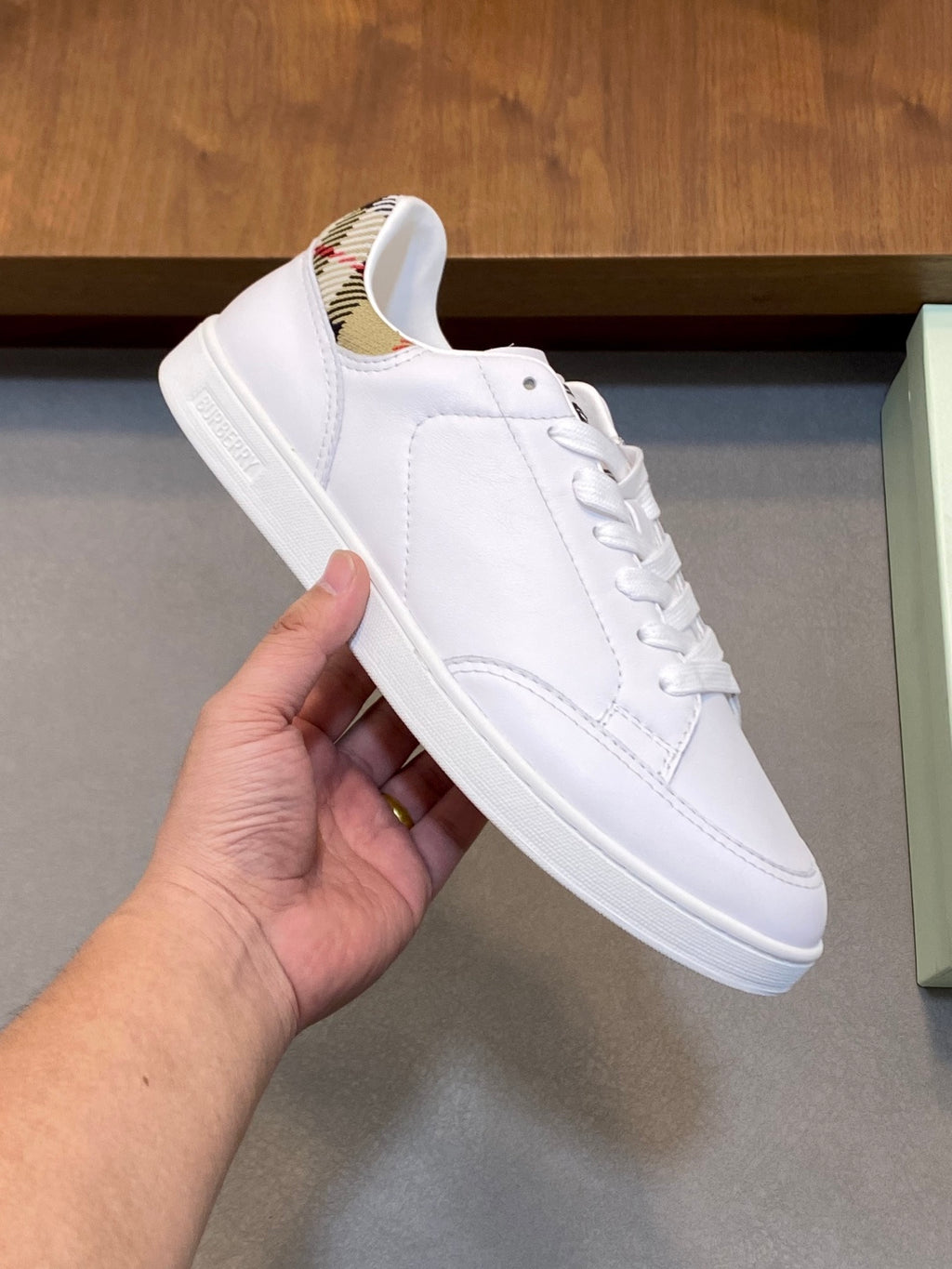 White leather lace-up sneaker with rubber sole and Burberry logo on tongue