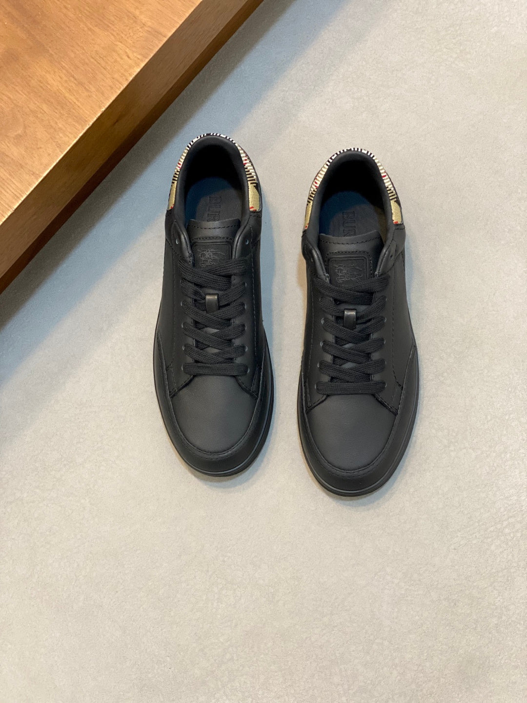 Black low-top lace-up sneakers with plaid heel detail