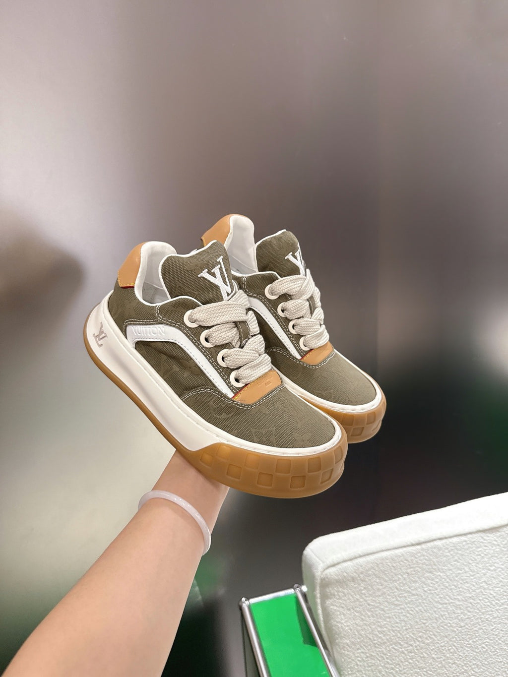 Unisex sneakers in olive with white laces and tan side trims, showing LV logo