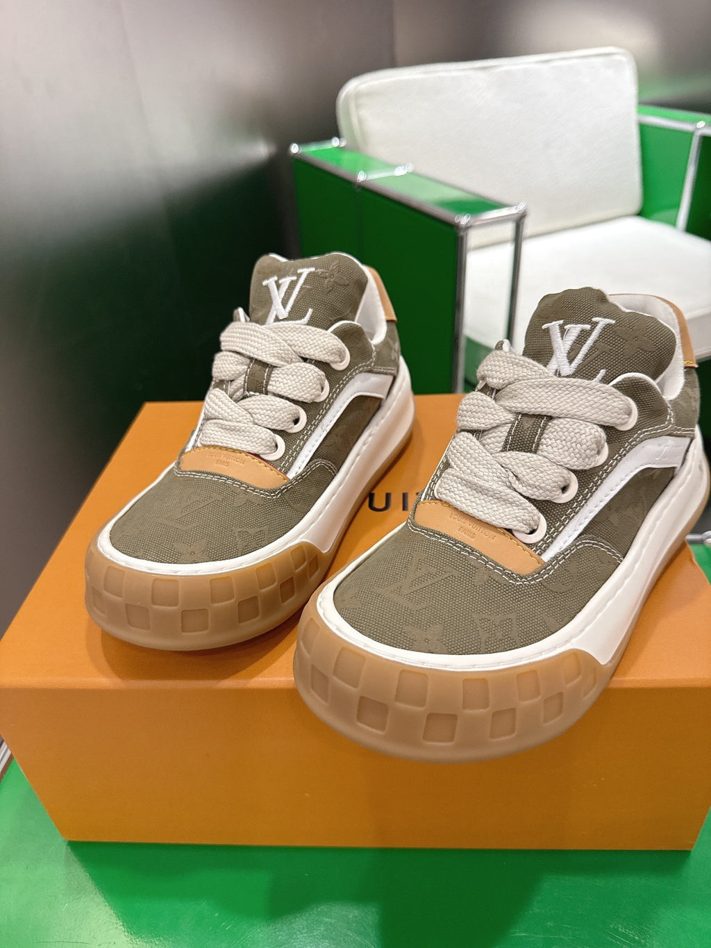 Unisex sneakers with olive uppers, white laces, tan side panels, and LV logo