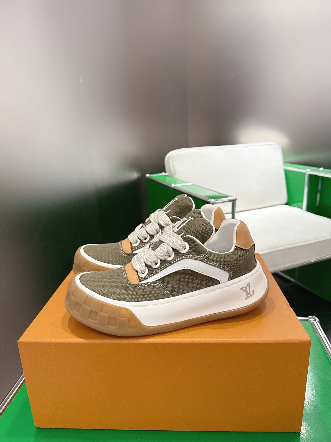 Unisex sneakers with olive uppers, white rubber sole, tan side patches, and LV logo