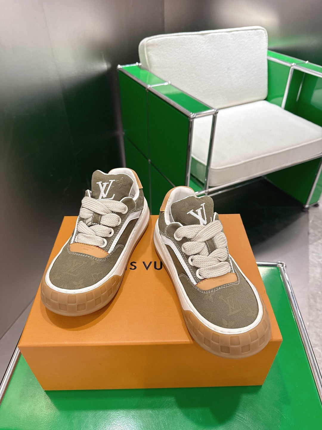 Unisex sneakers with olive uppers, white laces, tan heel accents, and LV logo