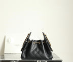Chanel black leather bucket bag with quilted texture, gold chain shoulder strap, and pouch top
