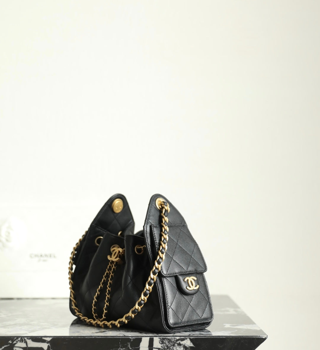 Chanel black leather mini bucket bag with gold chain strap and front logo emblem