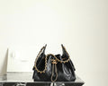Chanel black leather bucket bag with gold chain shoulder straps and drawstring top