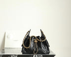 Chanel black leather bucket bag with gold chain shoulder straps and drawstring top