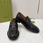 Gucci black leather loafers, side view, with red green stripe on the strap