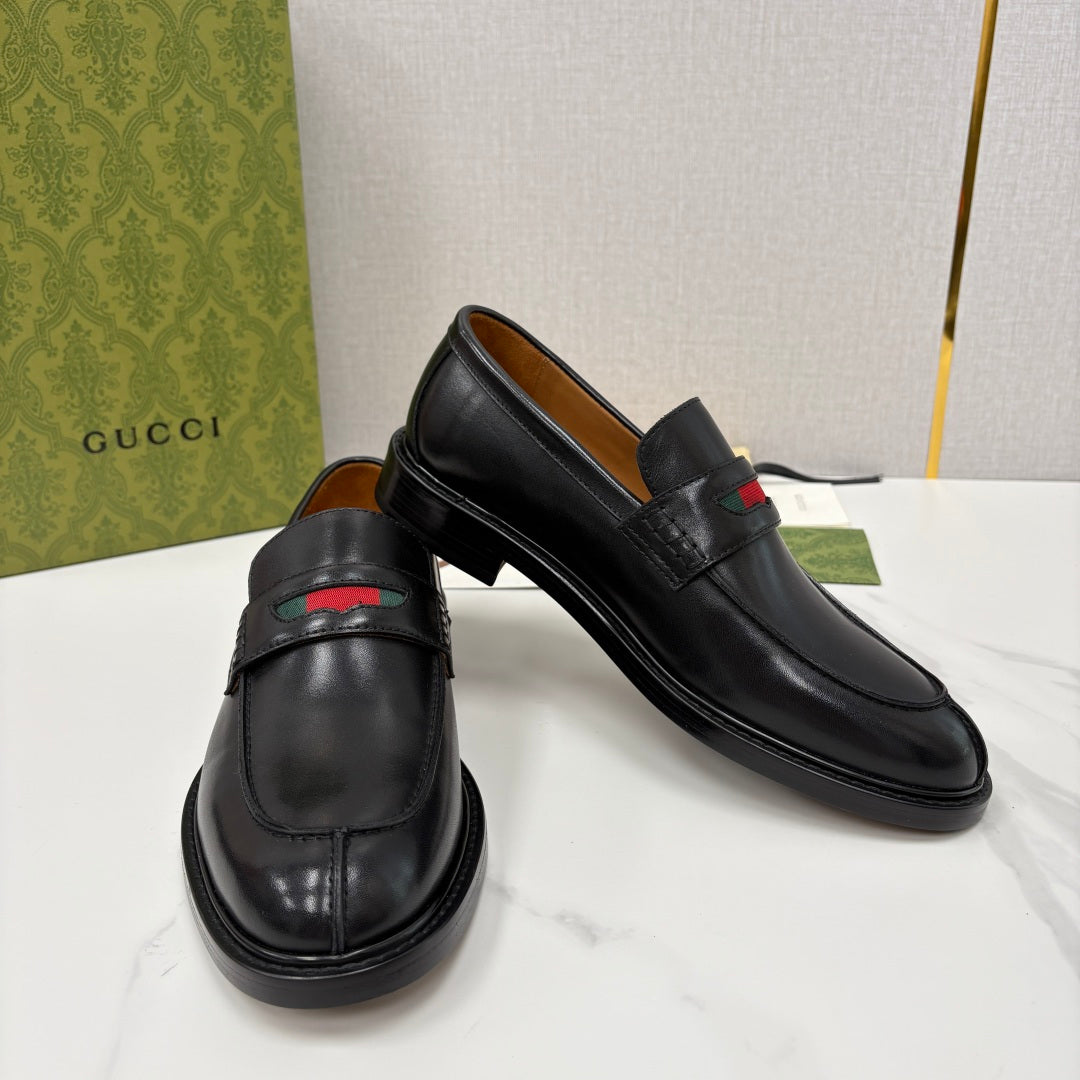 Gucci black leather loafers, side view, with red green stripe on the strap