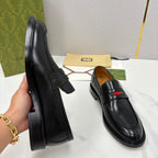 Gucci black leather loafers, angled side view, slip-on with red green stripe
