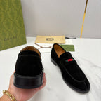 Gucci unisex black suede loafers with stacked heel, held by hand, stripe on top.