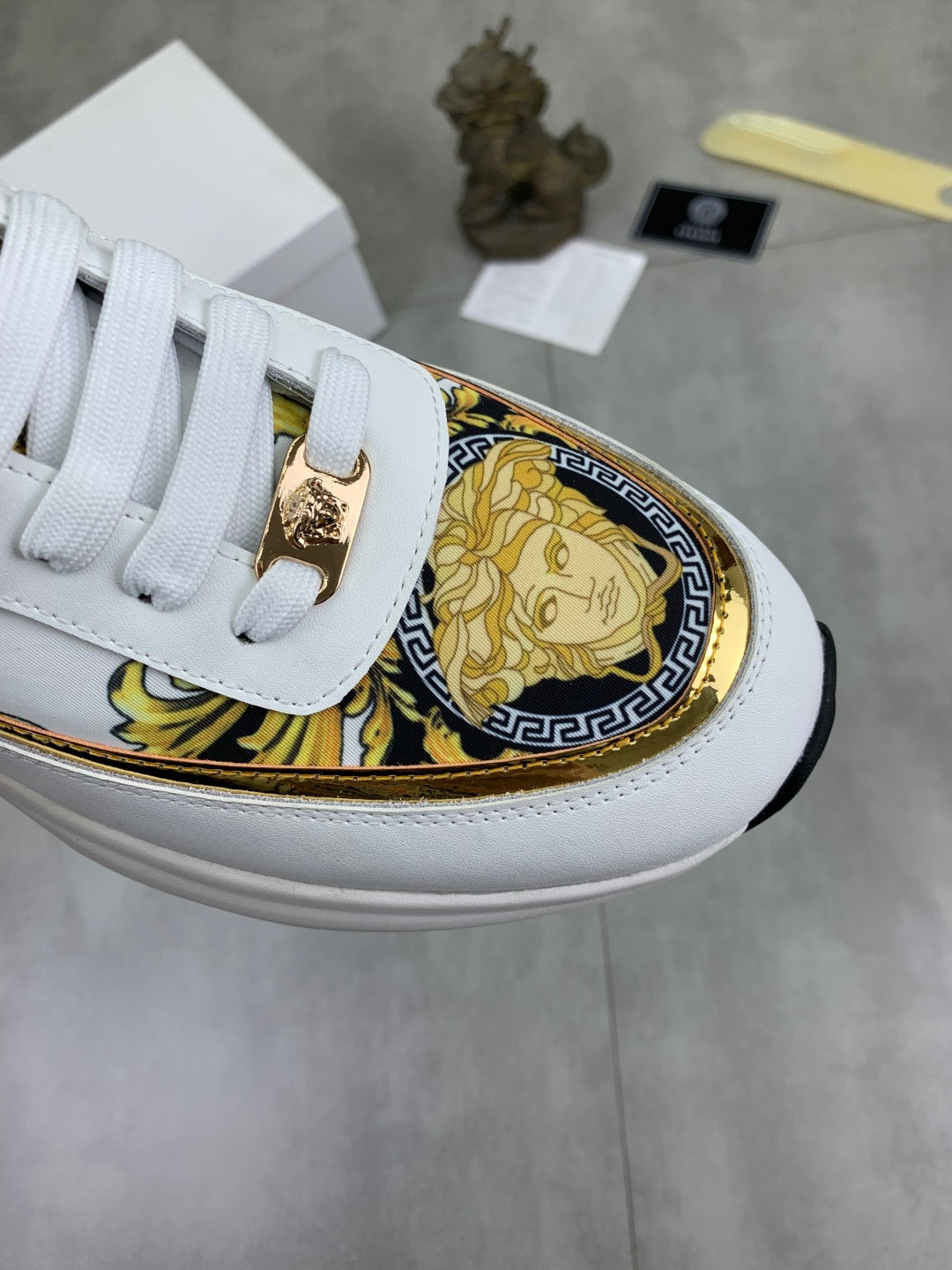 Versace white sneaker upper with gold decorative trim and emblem on the side panel