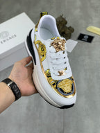 Versace white sneakers with gold baroque trim, medallion crest, and chunky black sole