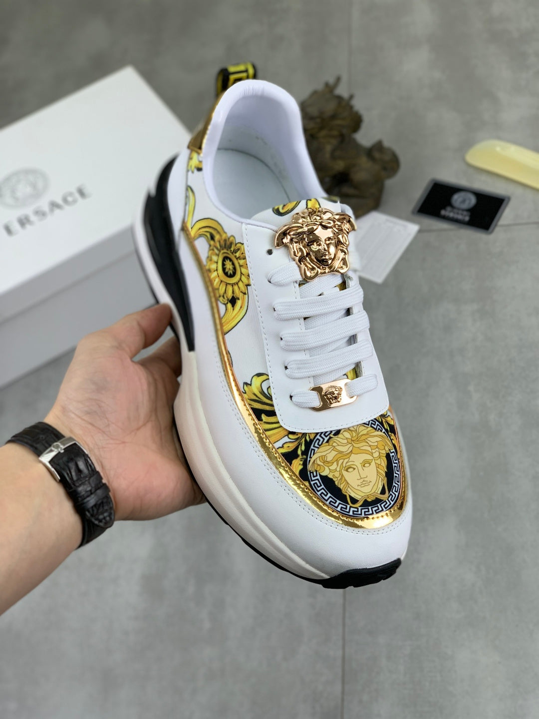 Versace white sneakers with gold baroque trim, medallion crest, and chunky black sole