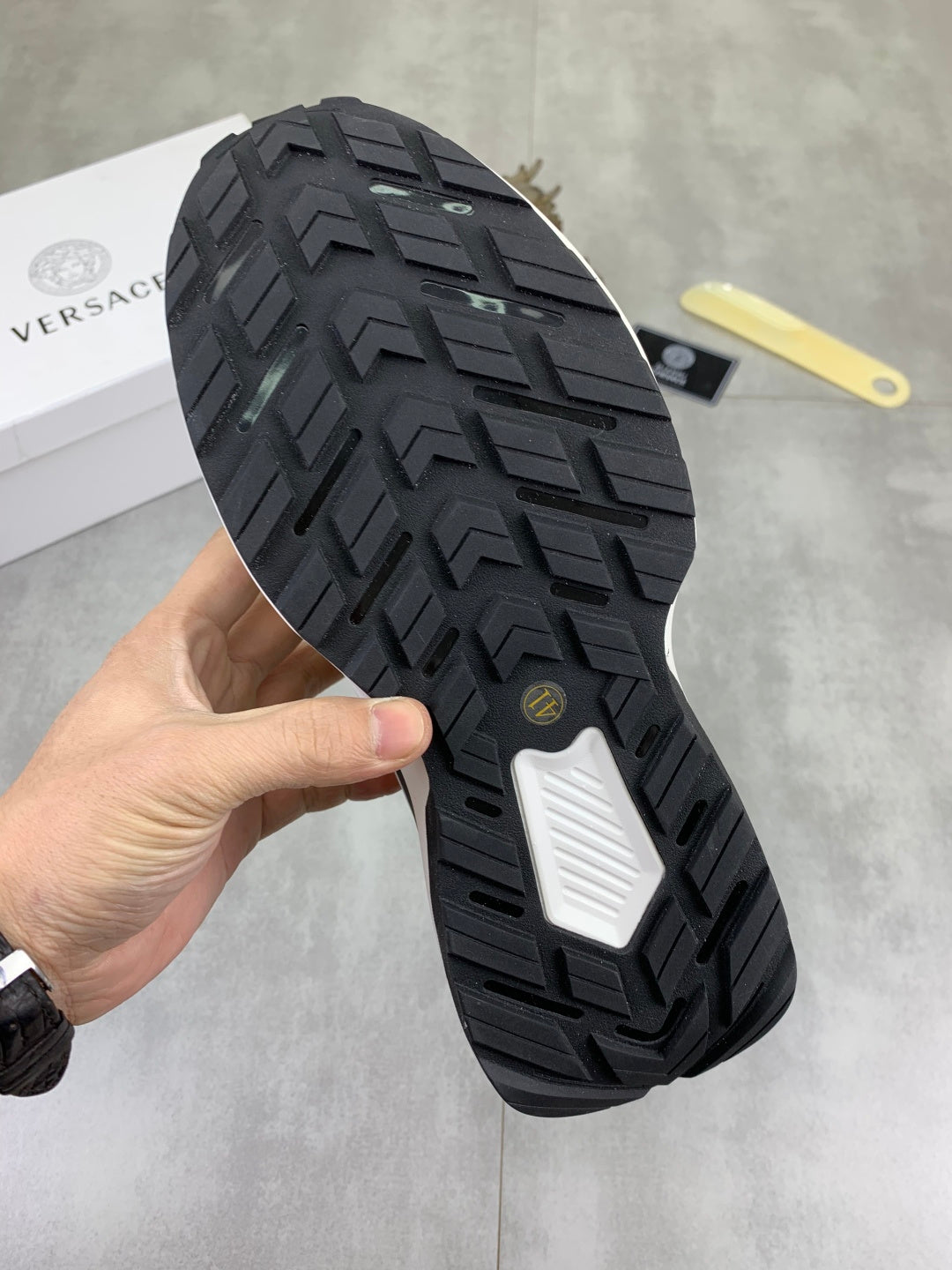 Versace sneaker outsole with dark tread pattern and textured traction grooves