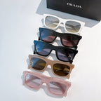 Stack of five sunglasses: white, black, blue, tan, and pink with gradient lenses